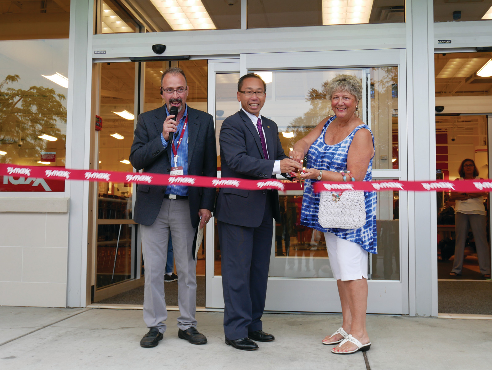 Store manager Carlos Laires, Cranston Mayor Allan Fung, and Sue Rotella, the first shopper in line to enter the store, cut the ribbon opening the new T.J. Maxx in Chapel View Mall in Cranston.