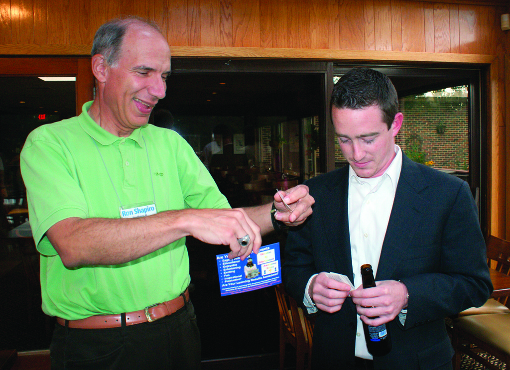 EXCHANGING BUSINESS CARDS: Ronald G. Shapiro, Ph.D. of Education by Entertainment exchanges business cards with Jeffrey Pratt of J. P. G. Designs.