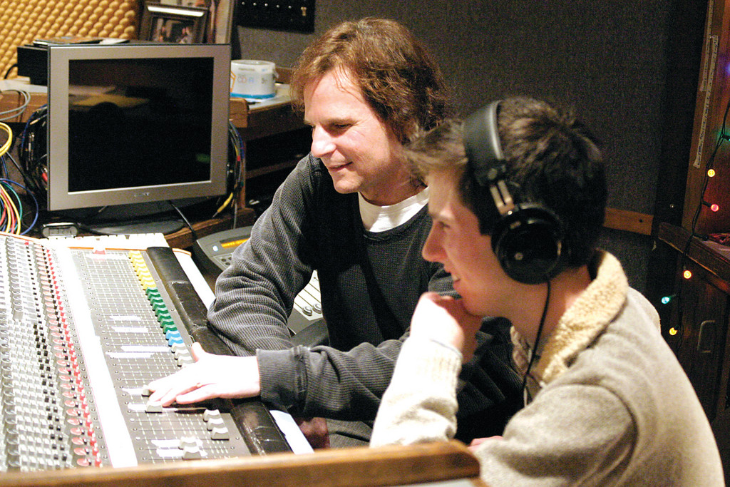 KEEPING TRACK: Record producer and engineer Jack Gauthier shows his son Jesse Liam how to get around a 24-track recording console at his Lakewest studio. The Greenville residents have recently released a CD of Jesse and Jack singing harmony.