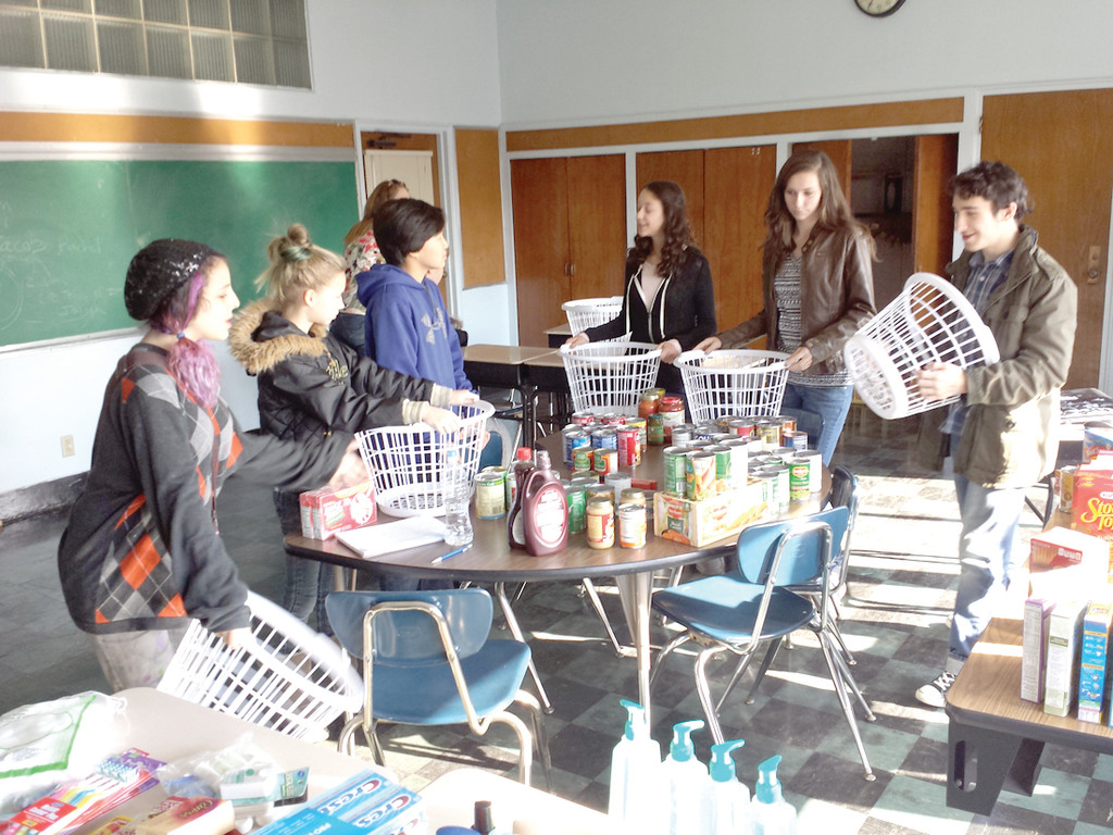 SERVICE PROJECT: The teen group from EnrichRI’s statewide home school program gathered together Thursday to divvy up the food items collected for their Thanksgiving baskets.