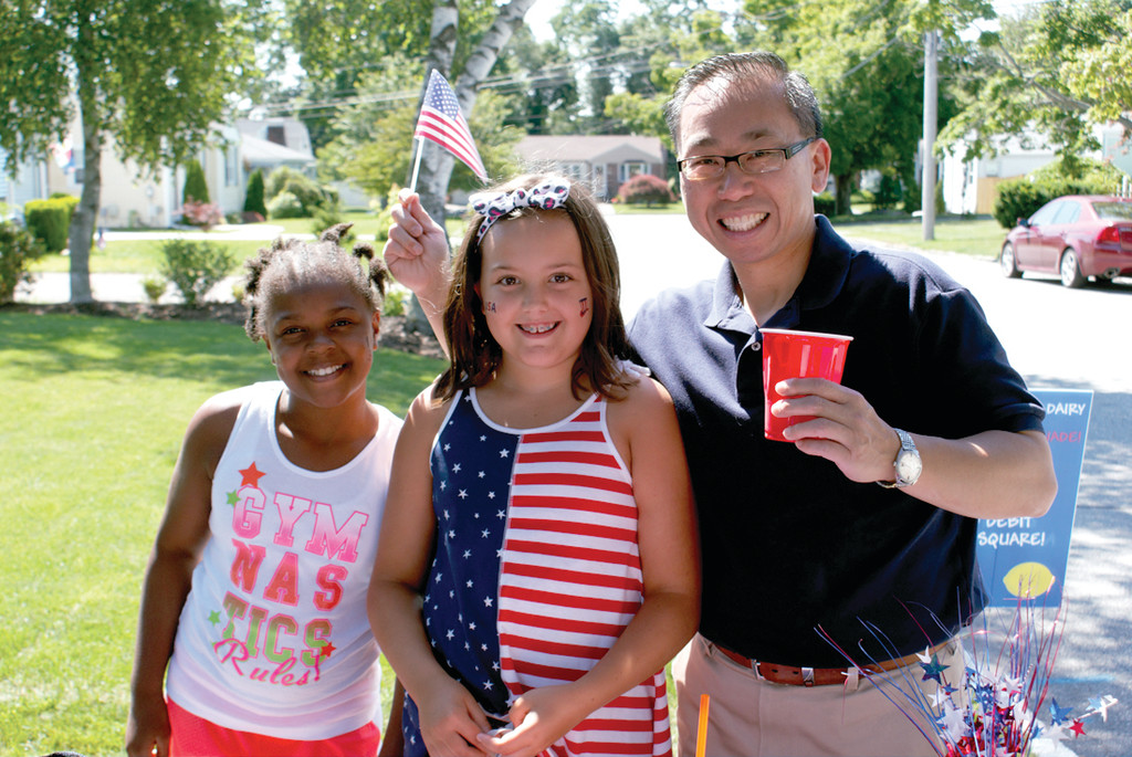 MAYORIAL SUPPORT: Supporting Olivia VanPatten’s dream of a lemonade stand to benefit Pets for Patriots was Mayor Allan Fung, who enjoyed the blueberry lemonade very much. He is pictured with Amani Jackson and Olivia VanPatten as he waves his American flag, which the girls gave out with every purchase.