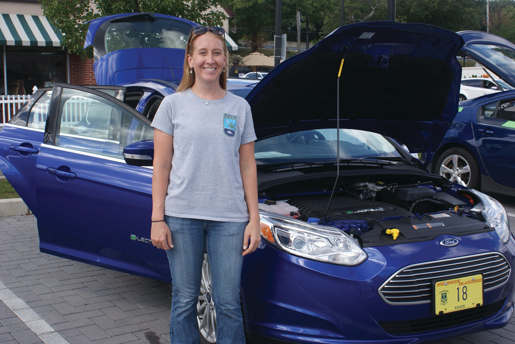 ON DISPLAY: Pictured in front of an all-electric Ford Focus is Allison Callahan, air quality specialist for the Department of Environmental Management. DEM now owns 12 electric vehicles for use as state vehicles. This car is operated by DEM Assistant Director Terry Gray.