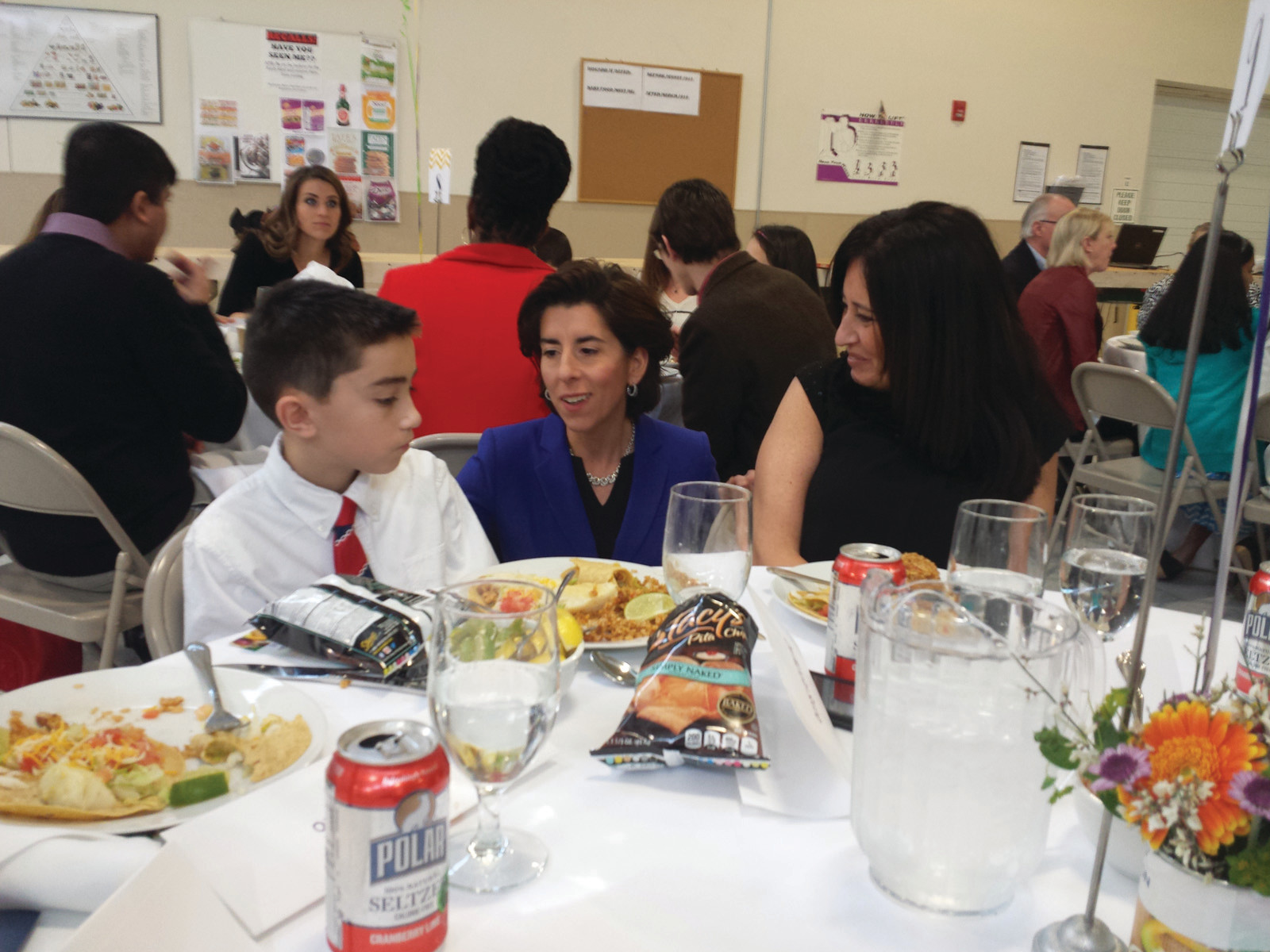 SHARING THE RECIPE: Gov. Gina Raimondo stopped to congratulate each of the finalists and their families and to talk to them about their winning recipes. Here, Cranston’s Nicholas Soccio, a fifth-grader from Immaculate Conception Catholic Regional School, describes his oven baked carrot fries as his mother, Jessica, looks on.