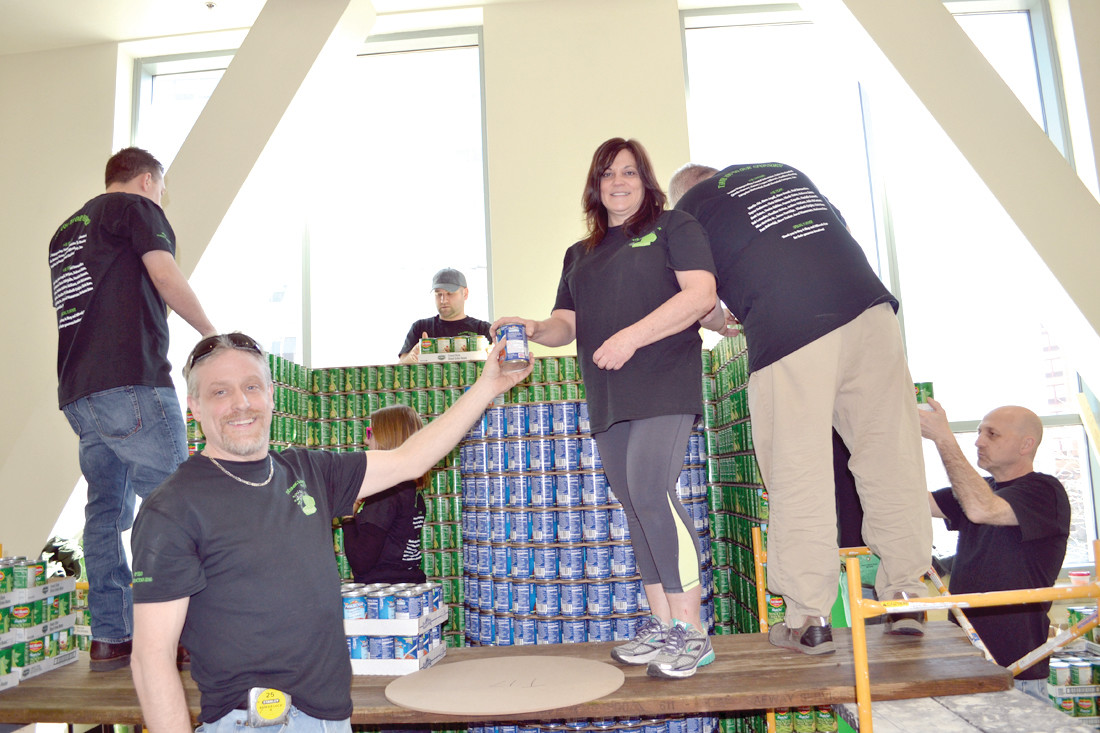 THE MAGIC LUNCHBOX and its contents begin to take shape as team captain Scott Eaton of Cranston and Pamela Stahowiak of Warwick work with other members of the Dimeo Construction-Edward Rowse Architects team. Their sculpture earned the Canstruction RI Honorable Mention award.