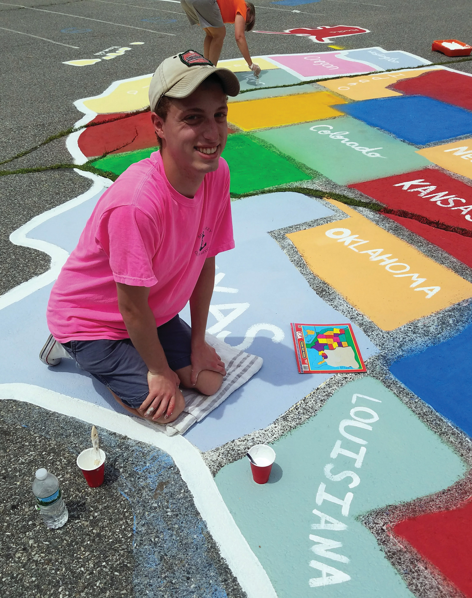 MANY HANDS: Marchetti was able to recruit many of his friends and family to come out on one of the hottest days of the month so far, to paint the blacktop with bright colors and designs for the students at Woodridge School.