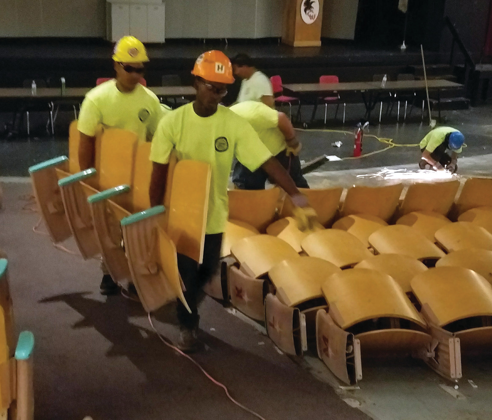 MANY HANDS MAKE LIGHT WORK: The newly minted grads work together to remove approximately 700 seats from the Cranston West auditorium as it undergoes its first renovation in 54 years.