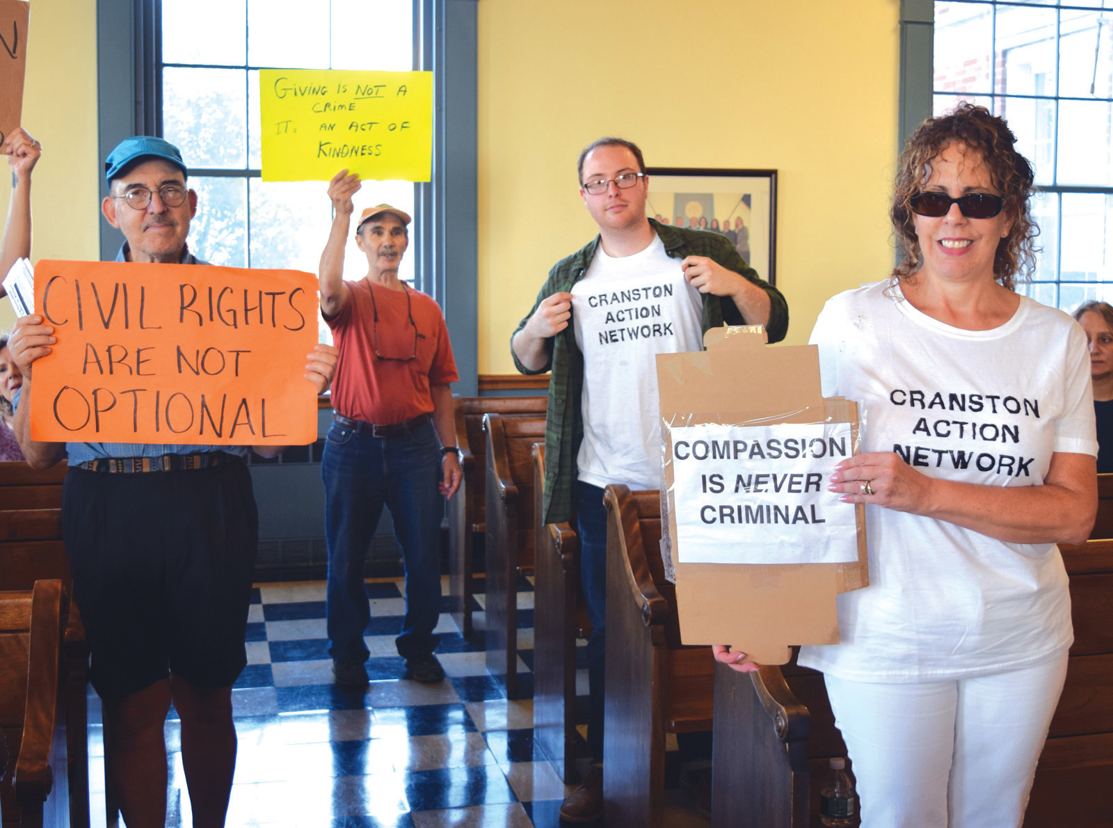 TAKING ACTION: John Donegan, in the middle holding up his shirt, and members of the Cranston Action Network took over the chambers on Thursday as the City Council went into executive session.