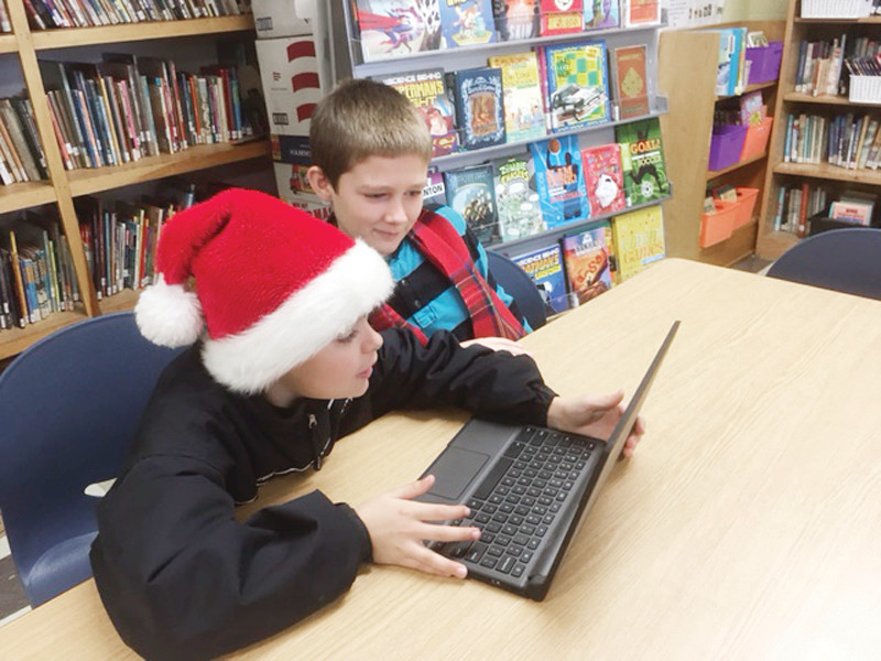 SANTA LEARNS TO CODE: Barrows Elementary fifth graders Christian and Raymond work on the “Google coding challenge” during Computer Science Week.