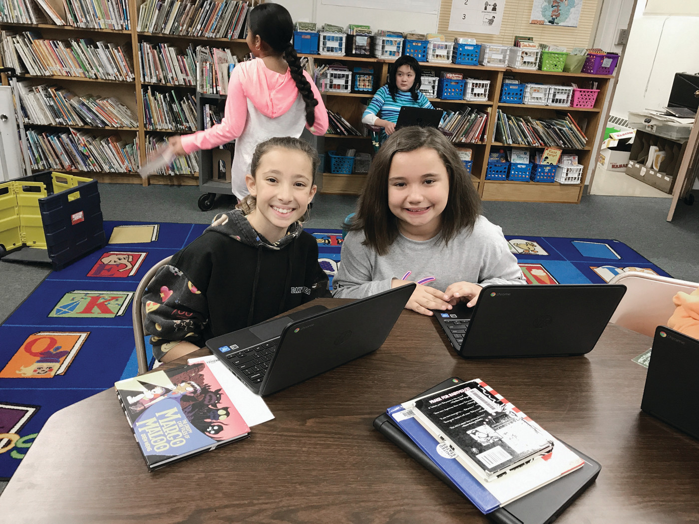 BEAMING FROM DEVICE TO DEVICE: Dutemple Elementary students show their coding prowess during library period.