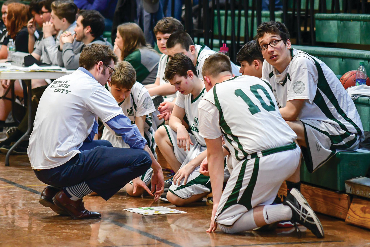 X’S AND O’S: The Bishop Hendricken unified basketball team gathers during a timeout during the 2018 season.
