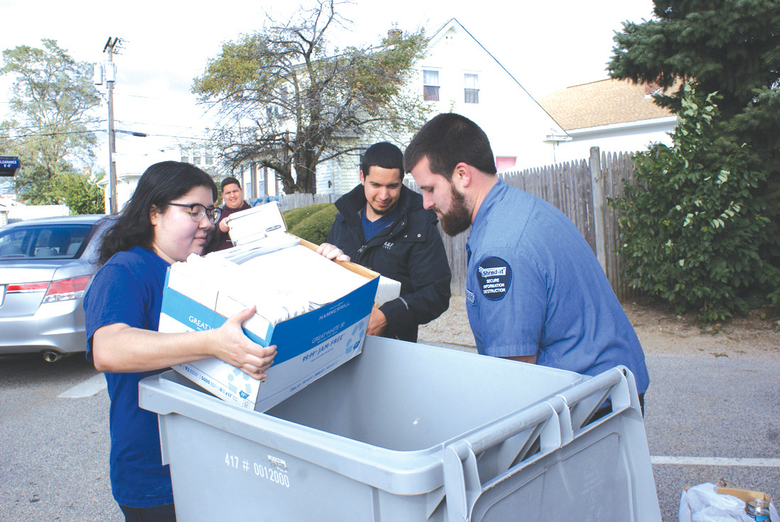 READY TO BE SHREDDED: Monica Almonte and Jack Torres, employees of Washington Trust Bank assist in the disposal of records along with Brian Scott from Shred It this past weekend.