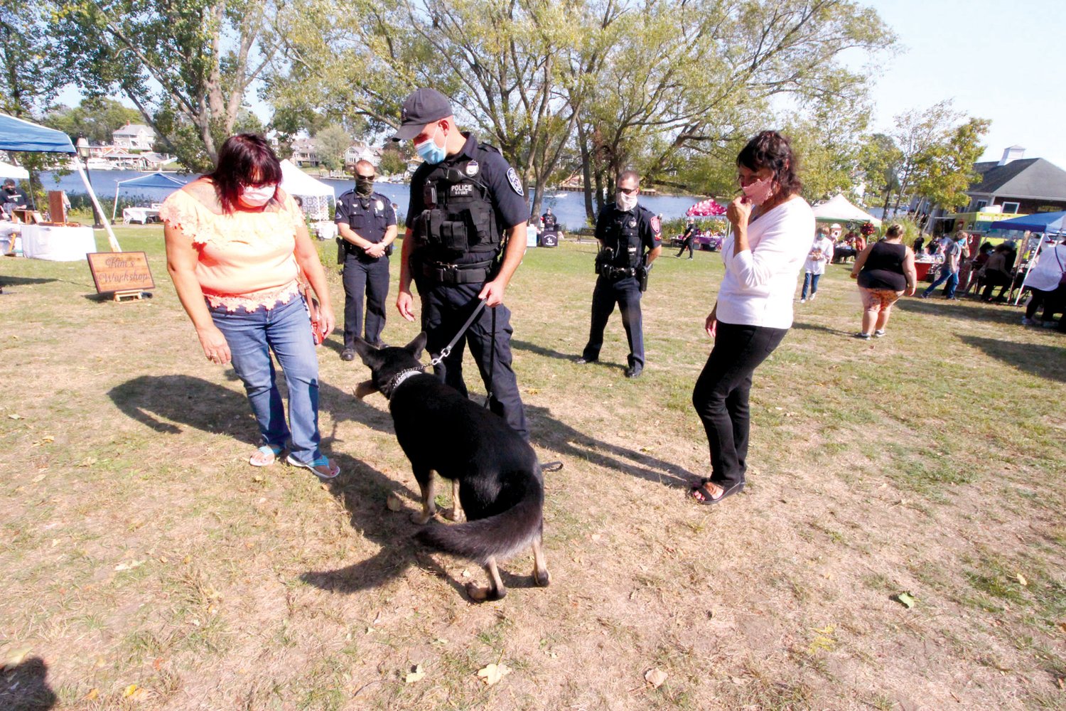 FRIENDLY K-9: Officer Tim Lipka introduces police dog Haki to Olivia Vendettoli and Diane D’Ambra as fellow Warwick officers Ryan Lancaster and Michael Isherwood look on during Saturday’s event. The K-9 unit was the beneficiary of $25 vendor fees to participate in the marketplace.