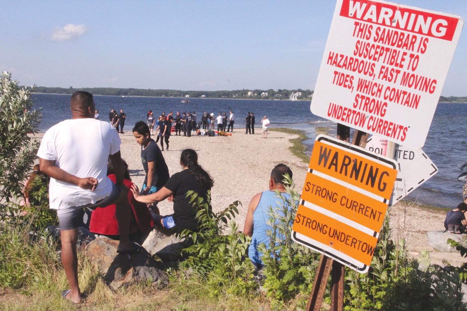 WARNINGS: Spectators gathered as police and fire conducted the recovery operation Sunday afternoon at Conimicut Point. Officials are considering means to emphasize the dangers shoal riptides.