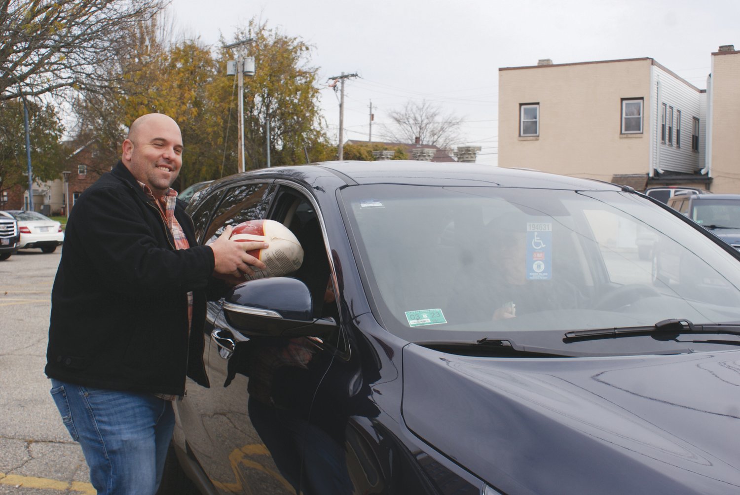 WITH SERVICE: Matthew Volpi, President of the St. Mary’s Feast Society, hand delivers a free frozen turkey to a family in need this holiday season.