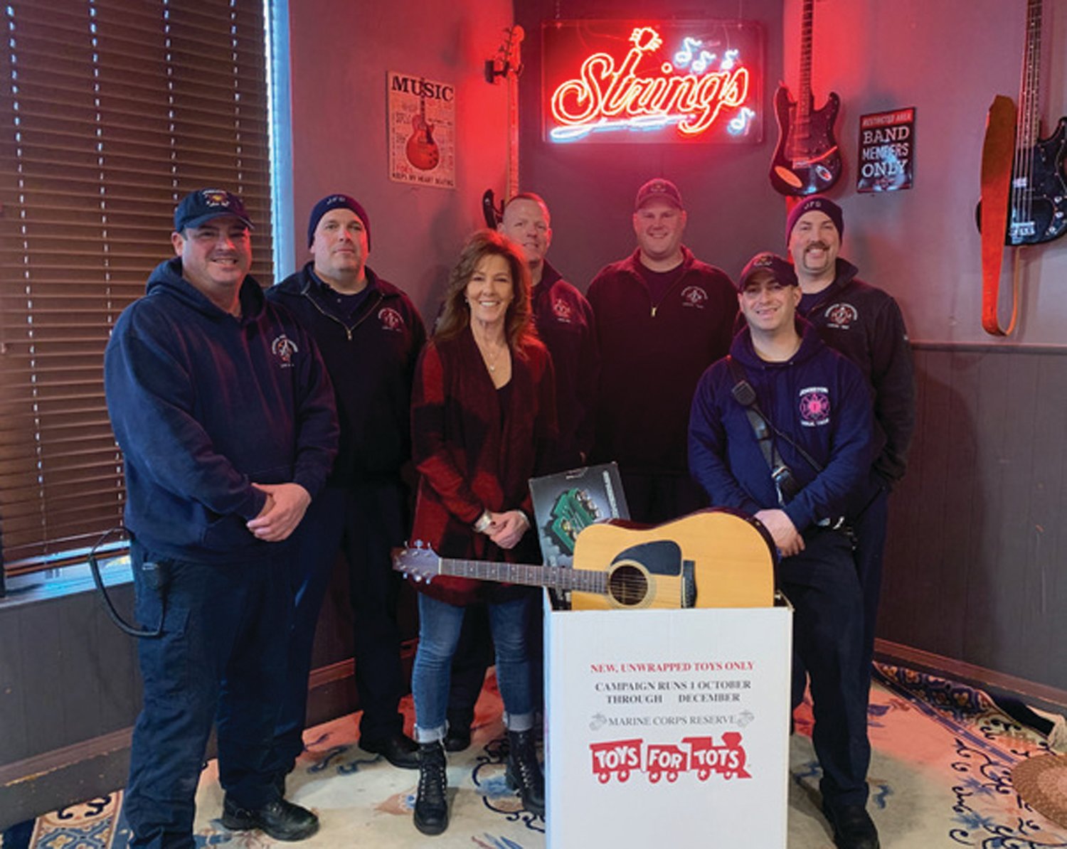 STEPH’S SUPER SANTA STAFF: Stephanie Harris, who owns and operates Strings Bar and Grill in Johnston, is joined by Local 1950 members Lt. Jon Pistacchio, Capt. Will Fish and firefighters Cory McNulty, Don Roberts, Chris DelFino and Mike Tetoile are hoping to break all previous records for Monday night’s Toys for Tots Party.