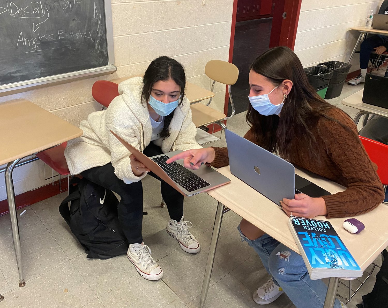 Cranston High School West Juniors Alexandra Zannini and Thea Marses consult on a piece of writing in English teacher and West alum Evan Lancia's Creative Writing class. Zannini, along with two Cranston West seniors, recently had the opportunity to read their poetry, on the topic of Equity, on National Public Radio.