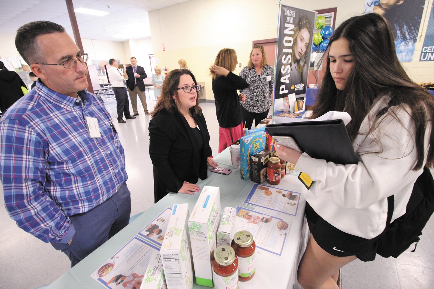 WHAT’S TO EAT? Alejandra Molina, from Madrid, Spain, who is spending her sophomore year at Toll Gate with the help of Stop & Shop em,ployees Howard Banspach and Lynne Amaral works out her monthly food budget.