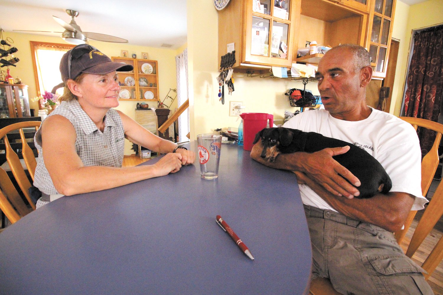 FEELING AT HOME: Filmmaker Karin Muller and Jody King of Warwick outline plans for a day of shooting at King’s kitchen counter. (Warwick Beacon photos)