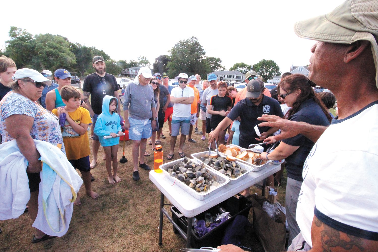 A TASTE OF THEIR FINDS: Before being served bowls of quahogs steamed in their own broth, Jody King gave the more than 50 participating in the free program co-sponsored by DEM and the Vet Center his father’s recipe. 