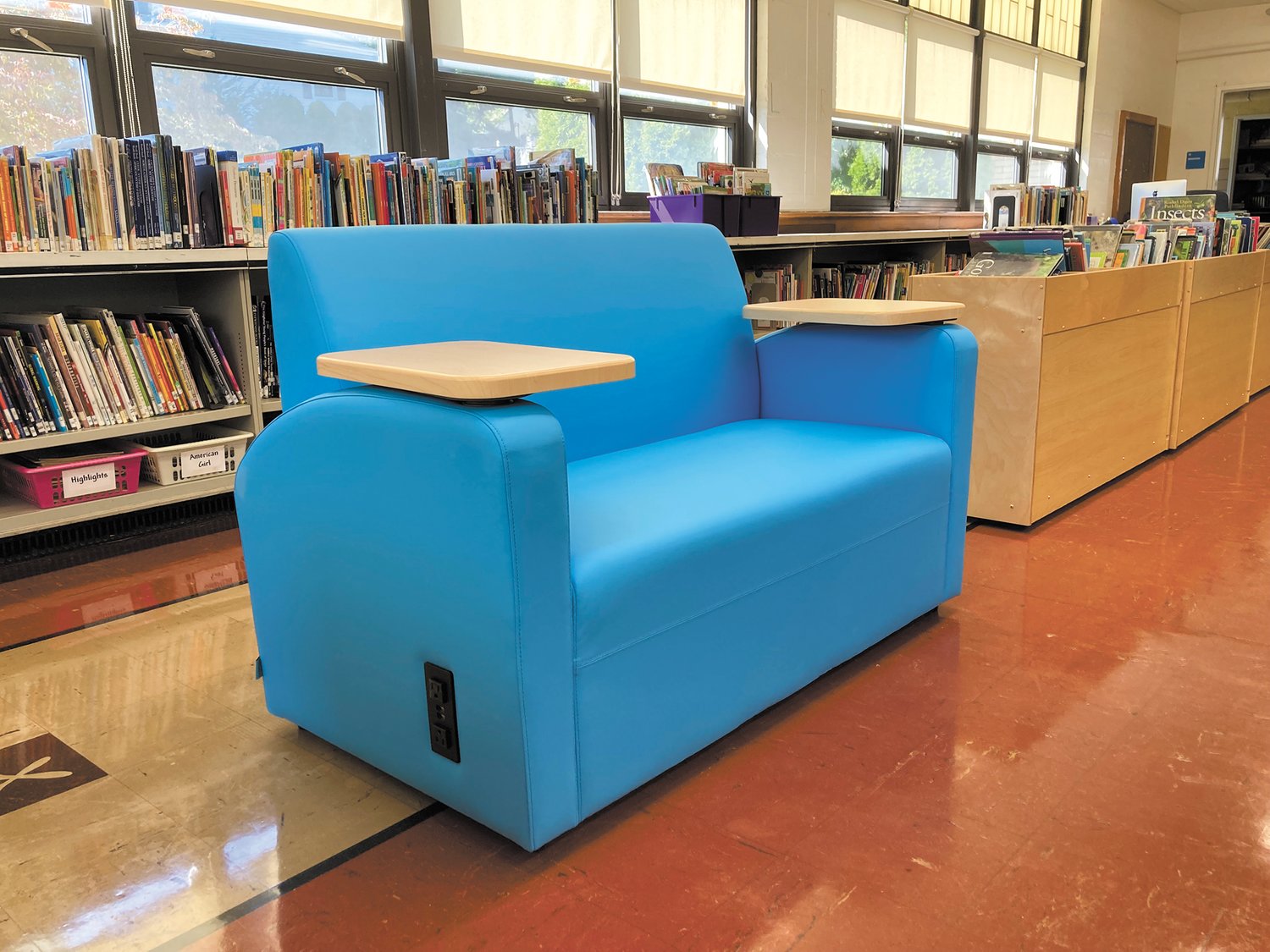 THEY ALL WANT THE COUCHES: Jackson said students all want to sit on the library’s two new, blue couches. This furniture has outlets on each side so students can plug in their laptops while working in this space. (Herald photo)