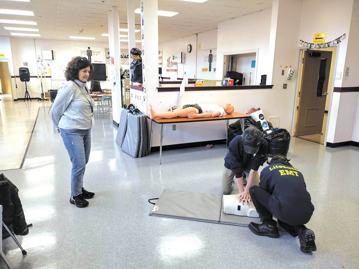 PREPARED FOR AN EMERGENCY: Lisa Tamburini observes as Pilgrim freshmen Will Auger and Ian Machado practice CPR. Both students are members of the Pilgrim Emergency Medical Team, a student organization on call for first aid at school events.