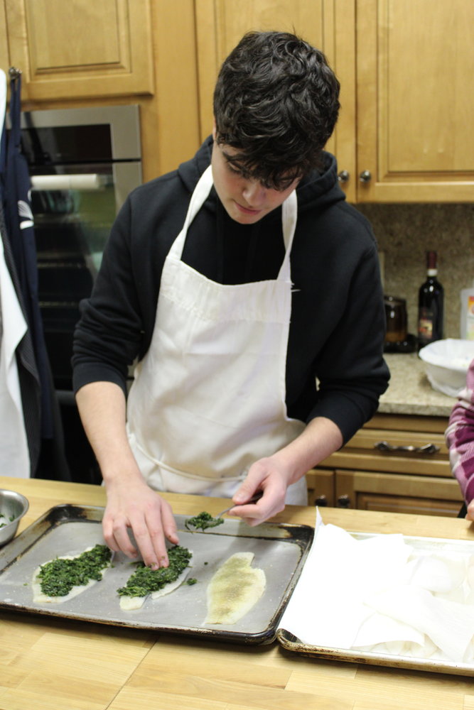 A TOUCH OF GREEN: College Student Mike Schena covers some filets of Sole with a spinach and garlic filling.