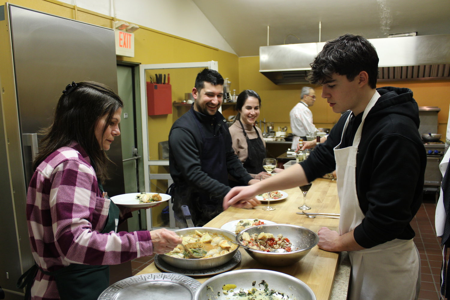 DON’T FORGET THE SAUCE: Dee Schena fills a plate to join the others in trying the delicious meal they’ve prepared.