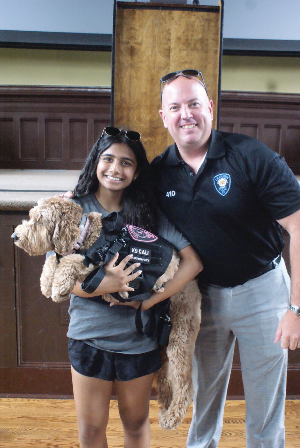 THERAPY AND A SNUGGLE: Shreya Ganguli gets a chance to meet and hold Cali as Detective Iacone smiles with pride at how well Cali has been trained.