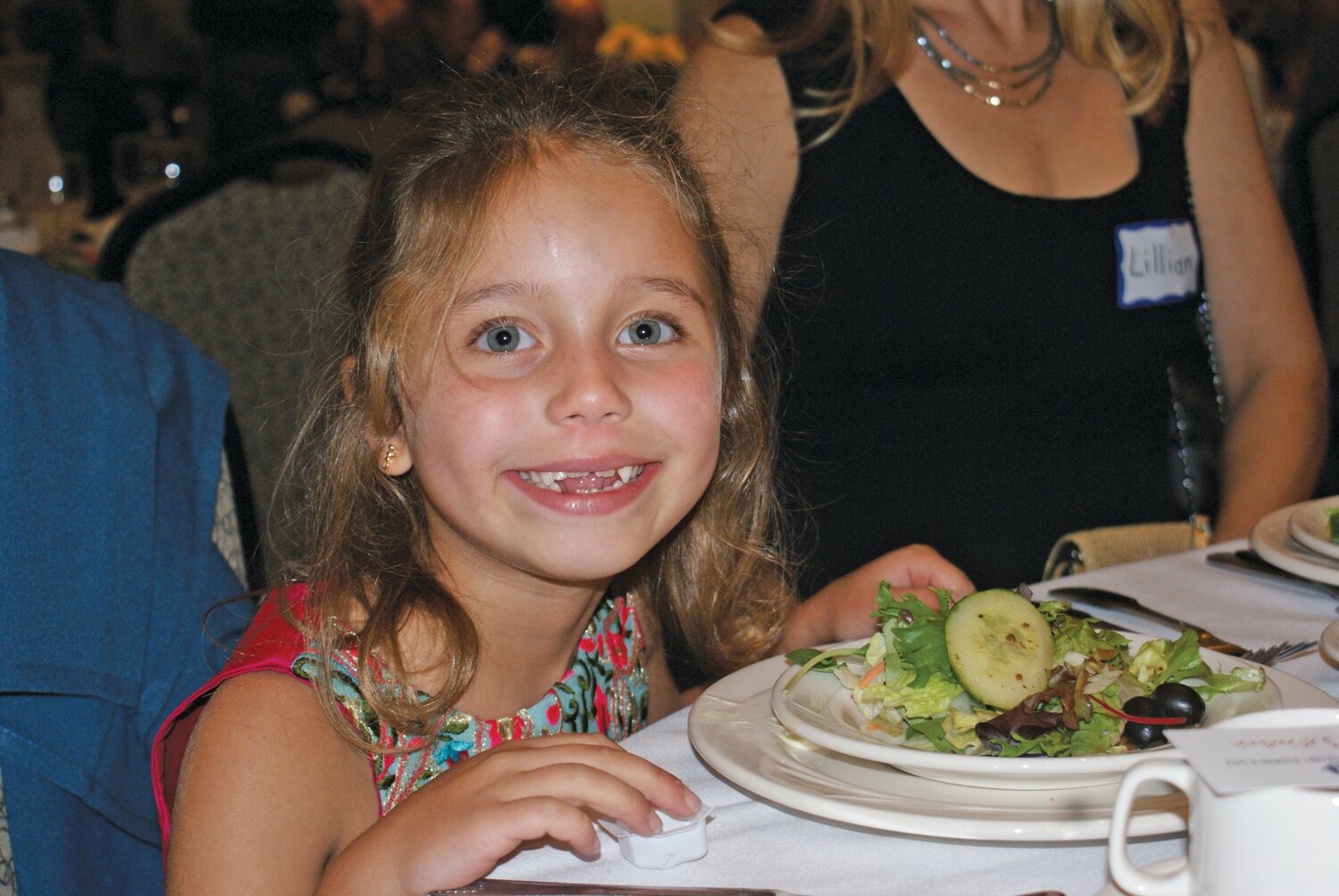 EATING A SALAD: Stella Chadwick, seven years old,  attends the ceremony with her mother,  Faculty Member Lillian Chadwick. (Photo by Steve Popiel)