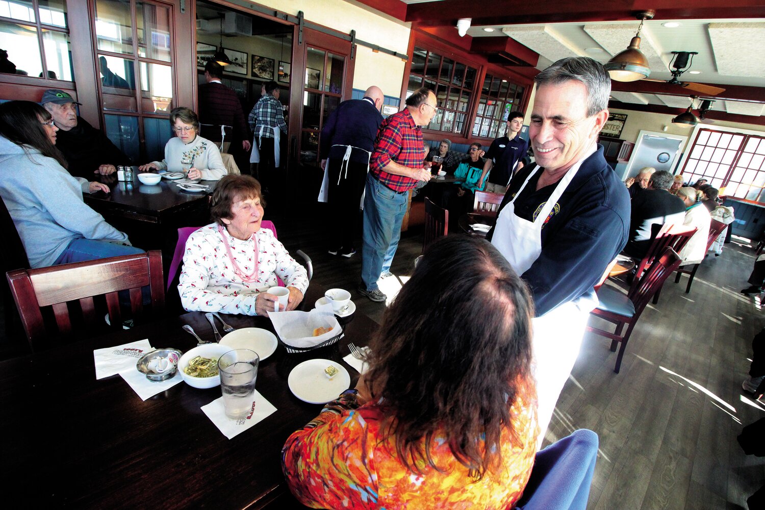 CHIT CHAT WITH THE MAYOR: Nancy Wunderler and her mother, Linda, who is a regular at the Pilgrim Senior Center get the low down from their waiter, Mayor Frank Picozzi.